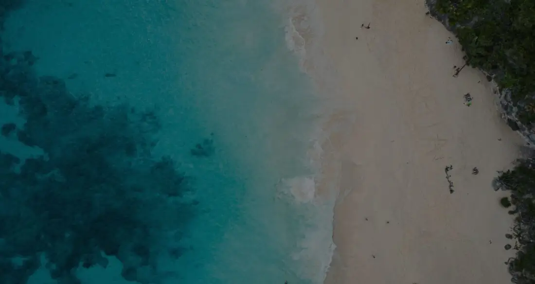 Costa de arena blanca y agua turquesa vista desde el aire